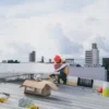 Solar technician working on rooftop installation of photovoltaic panels on a sunny day.